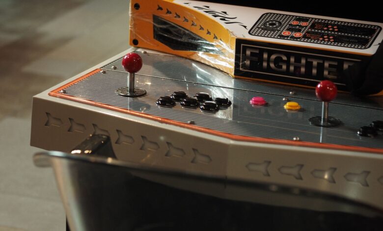 Close-up of a vintage arcade game control panel with joysticks and buttons.