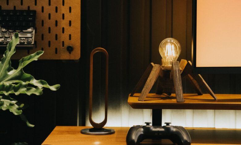 Stylish desk setup featuring a unique lamp, game controller, and plant for a contemporary workspace.