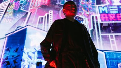 A man in a futuristic cyberpunk city with vibrant neon signs and lights.