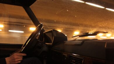 A view from inside a car driving through a brightly lit tunnel at night.