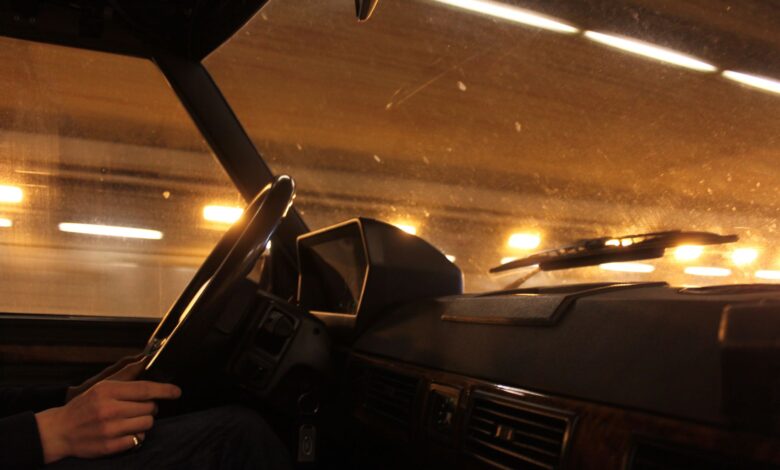 A view from inside a car driving through a brightly lit tunnel at night.