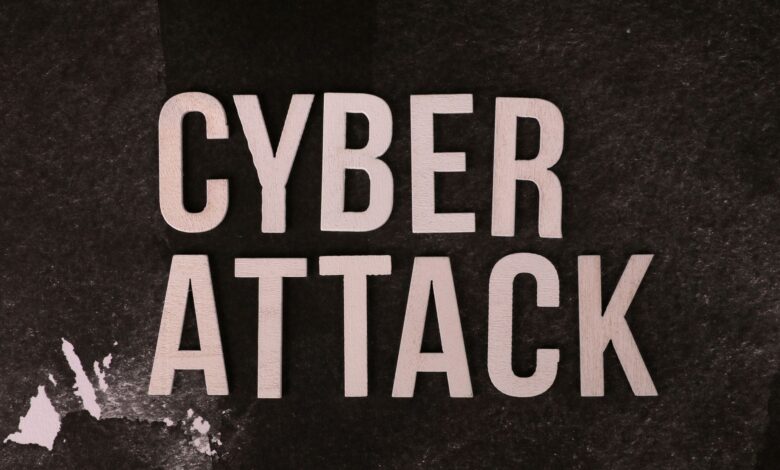 Text 'Cyber Attack' on textured dark paper highlights digital security threat concept.