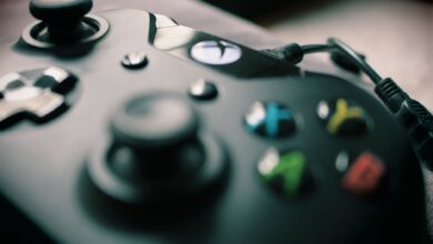 Detailed view of a black gaming controller showcasing its sleek design and colorful buttons.