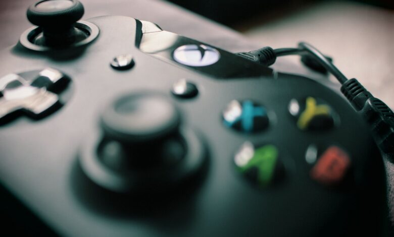 Detailed view of a black gaming controller showcasing its sleek design and colorful buttons.