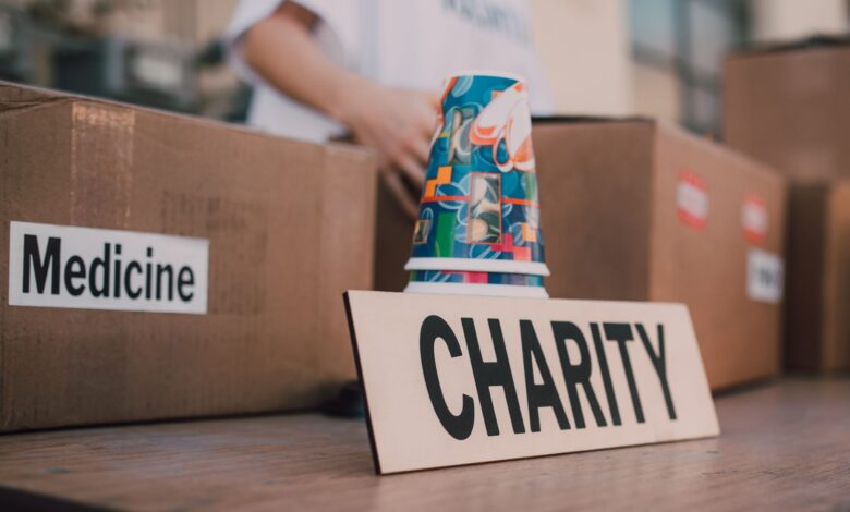 Close-up of charity boxes labeled for donation, featuring medicine and colorful paper cups.
