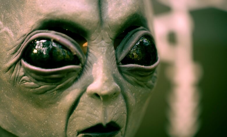 Detailed close-up of an alien face mask with black eyes, perfect for Halloween or sci-fi themes.