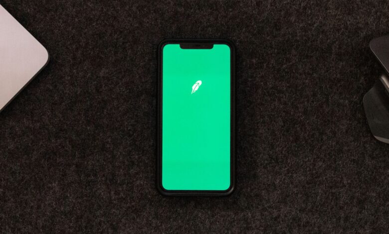 Smartphone displaying trading app on a desk for stock finance concepts.