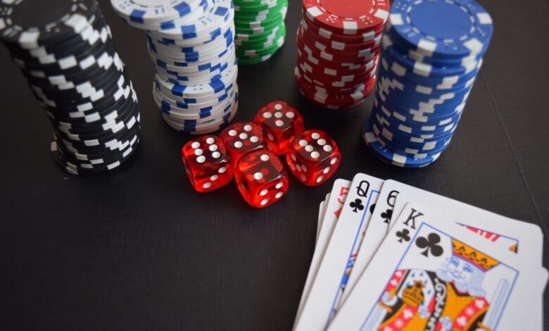 A vibrant display of casino chips, dice, and playing cards set on a table, embodying chance and excitement.