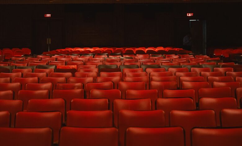Rows of empty red seats inside a classic movie theater with a vintage ambiance.