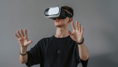 Young man explores virtual reality with VR headset, hands raised.