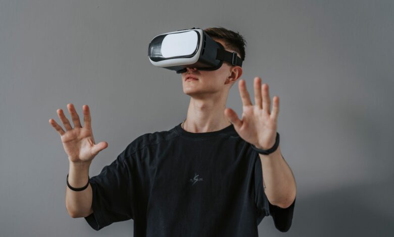 Young man explores virtual reality with VR headset, hands raised.