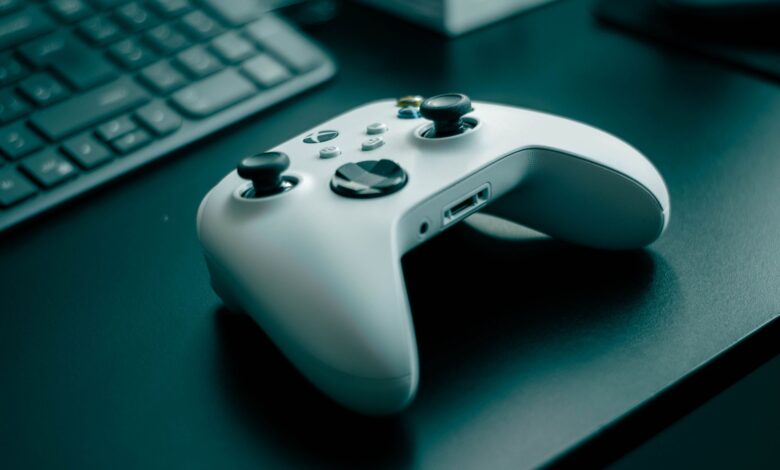 Close-up of a white game controller on a sleek desk, highlighting technology and gaming.