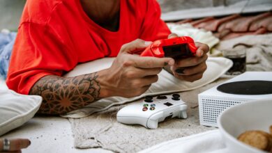 A person playing video games with a controller outdoors, showcasing leisure and technology.