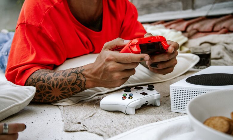 A person playing video games with a controller outdoors, showcasing leisure and technology.
