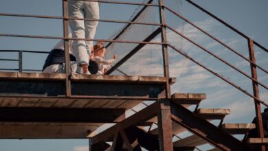 A family enjoys a relaxing time on a sunny outdoor platform with clear blue skies.