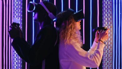 Two adults engaged in virtual reality gaming with VR headsets in a vibrant, neon-lit environment.