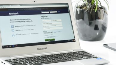 Open Samsung laptop showing Facebook sign-up page next to a potted plant. Ideal for technology themes.