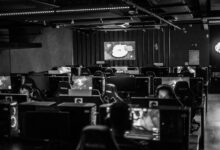 Black and white view of an active esports gaming studio with players immersed in video games.