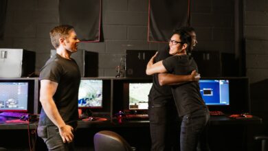 Young men celebrate a gaming win together in an eSport cyber cafe, exuding happiness and camaraderie.