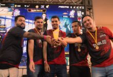 A group of gamers celebrating their victory at an e-sports event holding a trophy.