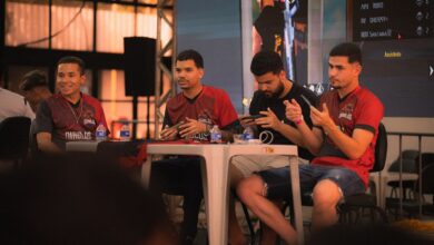 A group of e-sports players participating in a gaming event, focused on smartphone gameplay.