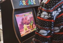A person in a sweater enjoying a classic arcade game in Zagreb, Hrvatska.