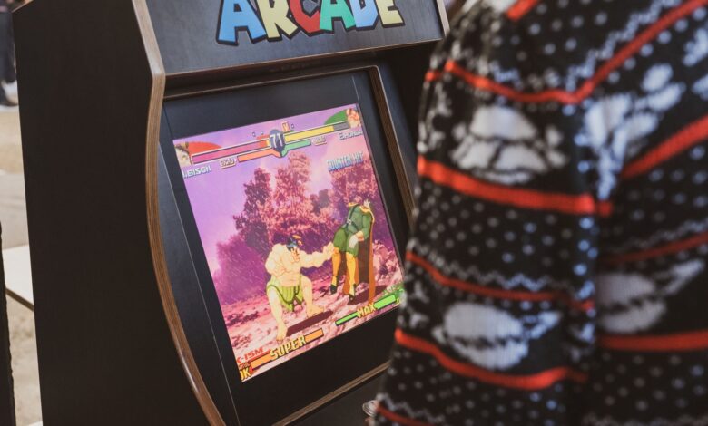 A person in a sweater enjoying a classic arcade game in Zagreb, Hrvatska.
