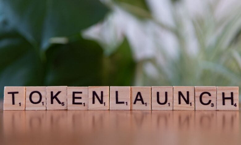 Scrabble tiles spelling 'Token Launch' on a vibrant green background.