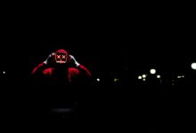 A spooky figure wearing a glowing LED mask in the darkness, perfect for Halloween themes.