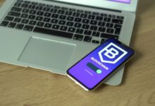 Smartphone displaying blockchain application resting on a laptop, symbolizing modern technology and finance.