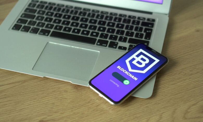 Smartphone displaying blockchain application resting on a laptop, symbolizing modern technology and finance.