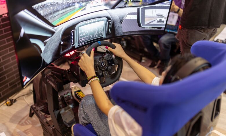 Person using a realistic VR racing simulator at a gaming event, focused on the immersive experience.