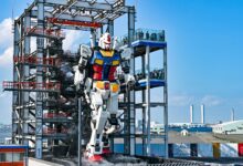 Life-sized Gundam robot at Gundam Factory Yokohama, Japan, in vibrant exterior daylight.