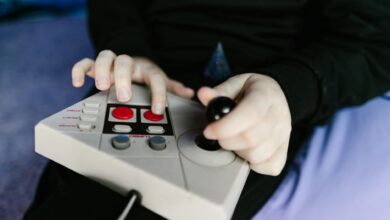 Hands gripping a retro gaming console joystick, showcasing classic gaming technology.