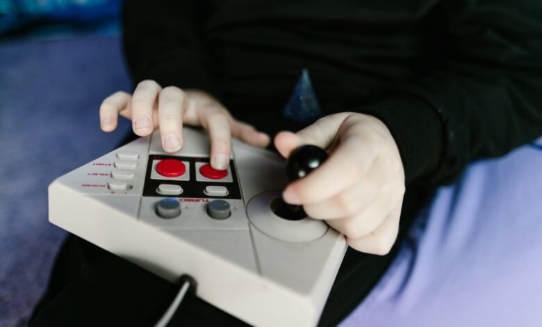 Hands gripping a retro gaming console joystick, showcasing classic gaming technology.