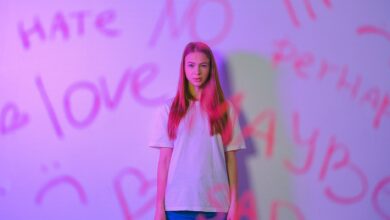 Expressive studio portrait of a teenager with graffiti, capturing emotion and mood with a pink hue.