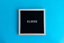 A letter board with 'Closed' displayed against a vibrant blue backdrop, signifying a closure or notice.