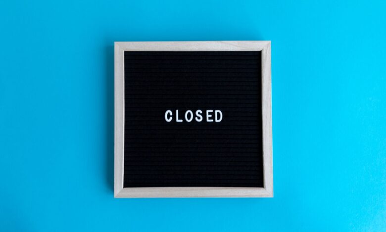 A letter board with 'Closed' displayed against a vibrant blue backdrop, signifying a closure or notice.