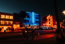 Colorful neon lights and lively street scene on Ocean Drive, Miami Beach, FL.