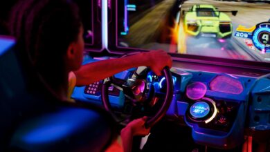 A person playing an immersive arcade racing game with vibrant lights.