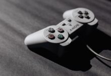 Retro Sony game controller with classic buttons on a textured dark surface, showcasing vintage electronics.