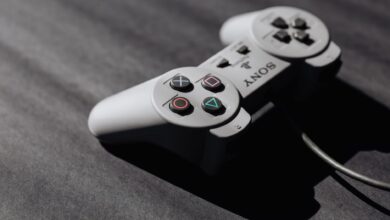 Retro Sony game controller with classic buttons on a textured dark surface, showcasing vintage electronics.