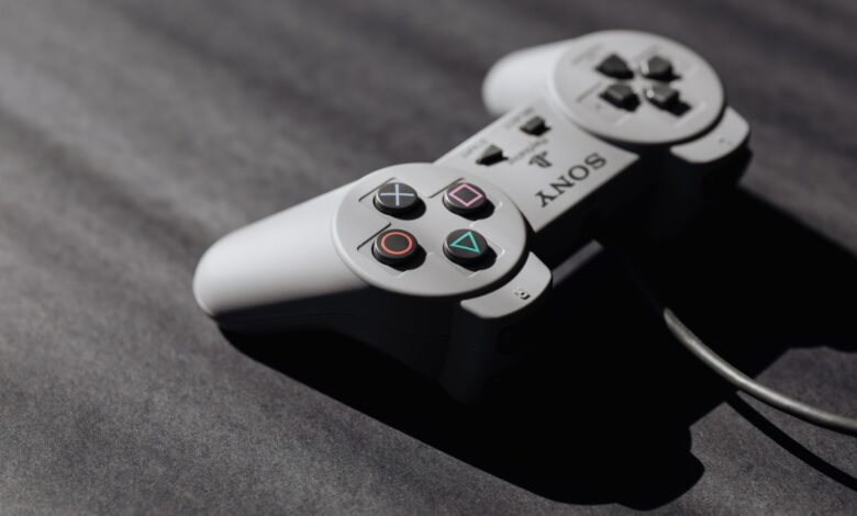 Retro Sony game controller with classic buttons on a textured dark surface, showcasing vintage electronics.