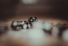 Artistic photo of multi-sided gaming dice in a blurred setting, highlighting the number 20.
