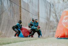 Group of players in action during a competitive paintball match outdoors.