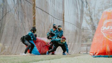 Group of players in action during a competitive paintball match outdoors.