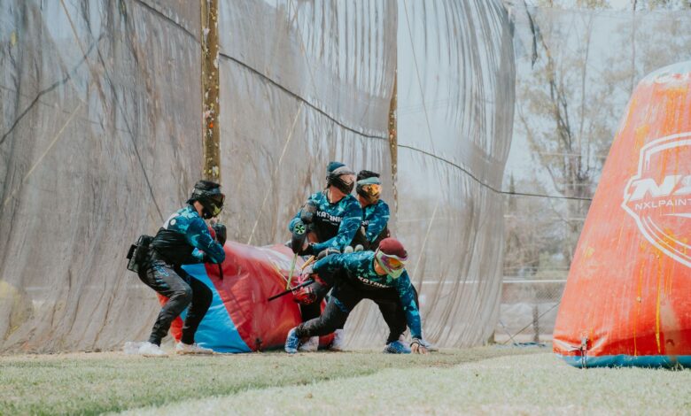 Group of players in action during a competitive paintball match outdoors.