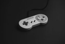 Close-up of a vintage Super Nintendo controller on a black background.