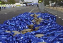 Stack of medals with blue ribbons at Sevilla Marathon, ready for winners' arrival.