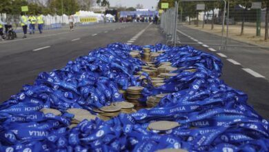 Stack of medals with blue ribbons at Sevilla Marathon, ready for winners' arrival.